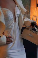 Close-up of the gathered plunge neckline and fitted waist of an ivory maxi dress