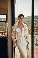 Front three-quarter view of an ivory plunge neck maxi dress with gathered bodice and thin straps