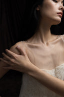 Close view of clear beaded straps and textured ivory bodice