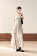 Model wearing a khaki cotton and spandex petite maxi dress with non-adjustable straps and an A-line skirt