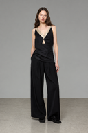 Black and matcha green layered camisole top styled with wide-leg black trousers, full-length front view