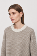 Liorine wool crewneck sweater on model, close-up of ivory rib neckline and oatmeal textured knit