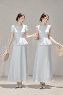 Two models wearing the VOGSION Mirelle petite faux two-piece peplum maxi dress in Light Blue, shown in Puff Sleeve and Sleeveless styles.