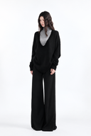 Nerine black deep-V knit sweater layered over grey mock-neck top, full-length styling view