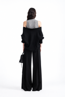 Back view of Nerine black relaxed knit sweater layered over grey mock-neck top