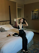VOGSION Nocturne black and white two-piece evening pants set shown seated with wide-leg trousers