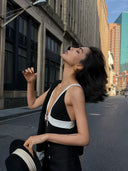 Close view of the VOGSION Nocturne black and white deep V-neck top with contrast trim and ring detail