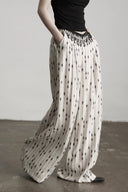 Side motion view showing the ultra-wide floor-length pant legs