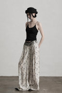Three-quarter view of ivory and black geometric wide-leg pants