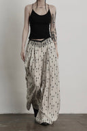 Front walking view of floor-length ivory and black wide-leg pants