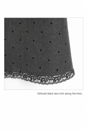 Close-up of charcoal polka dot fabric and delicate black lace hem on the Odeline dress