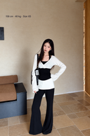 Petite black and white faux-layer long-sleeve top with black trousers, hand-on-hip pose; model 158 cm, 40 kg, size XS