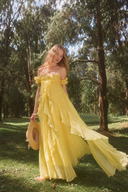 VOGSION Rosalie butter yellow off-shoulder ruffle maxi dress outdoors, front view