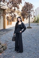 Black petite rosette knit three-piece set, model posing with one hand on hip