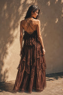 Back view of the Vogsion Seraphina Tiered Chantilly Lace Maxi Dress in chocolate brown featuring an elegant open-back silhouette, adjustable cross straps, cascading lace layers and graceful movement for formal occasions.