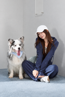 Model seated beside a dog wearing the Sorelle petite navy hoodie and wide-leg pant set.