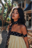 Close-up portrait of Vogsion Velvandis Off Shoulder Dot Mini Dress (Sage Green Polka Dot), highlighting the off-shoulder neckline, polka dot trim, flowing lightweight fabric and soft romantic silhouette. A chic women’s summer mini dress for vacations, resort wear, café dates and effortless feminine fashion
