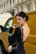 Deep open-back and sheer eyelash-lace detail on VOGSION Vespera black mini dress