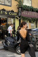VOGSION Vespera black lace-back ruched mini dress in a Paris street setting