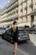 Full-body rear view of VOGSION Vespera black open-back long-sleeve mini dress