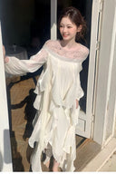 Front view of VOGSION white long sleeve formal maxi dress with crystal neckline and flowing ruffles