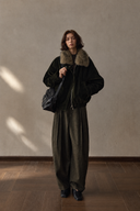 Olive wool-blend trousers styled with a fur-collar jacket, front view.