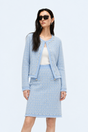 Front view of a light blue wool-blend tweed jacket and knee-length skirt set with pearl-effect trim.
