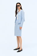Full-length side view of the light blue tweed jacket and matching knee-length skirt.